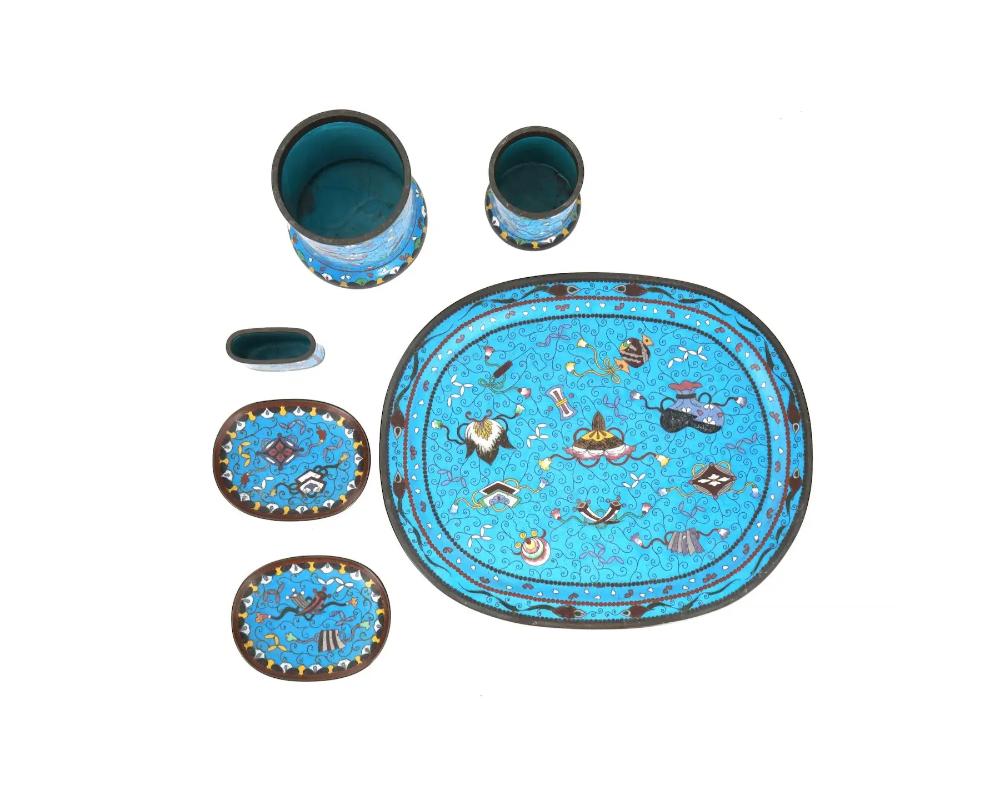 A Japanese Meiji period cloisonne enamel writing set comprising 6 pieces decorated in the same style with floral patterns, including an oval tray, two plates and three cups of various shapes. Cloisonne is a traditional Japanese enamelwork technique