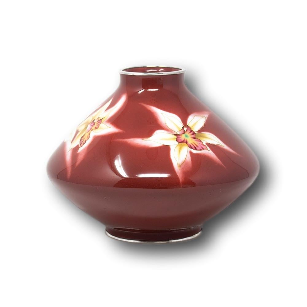 Japanese cloisonne enamel orchid vase early Showa period. The vase of squashed form boldly decorated with a fine red ground enamel. To the central band beautifully placed orchids grace the red enamel with colours of white with tints of yellow and