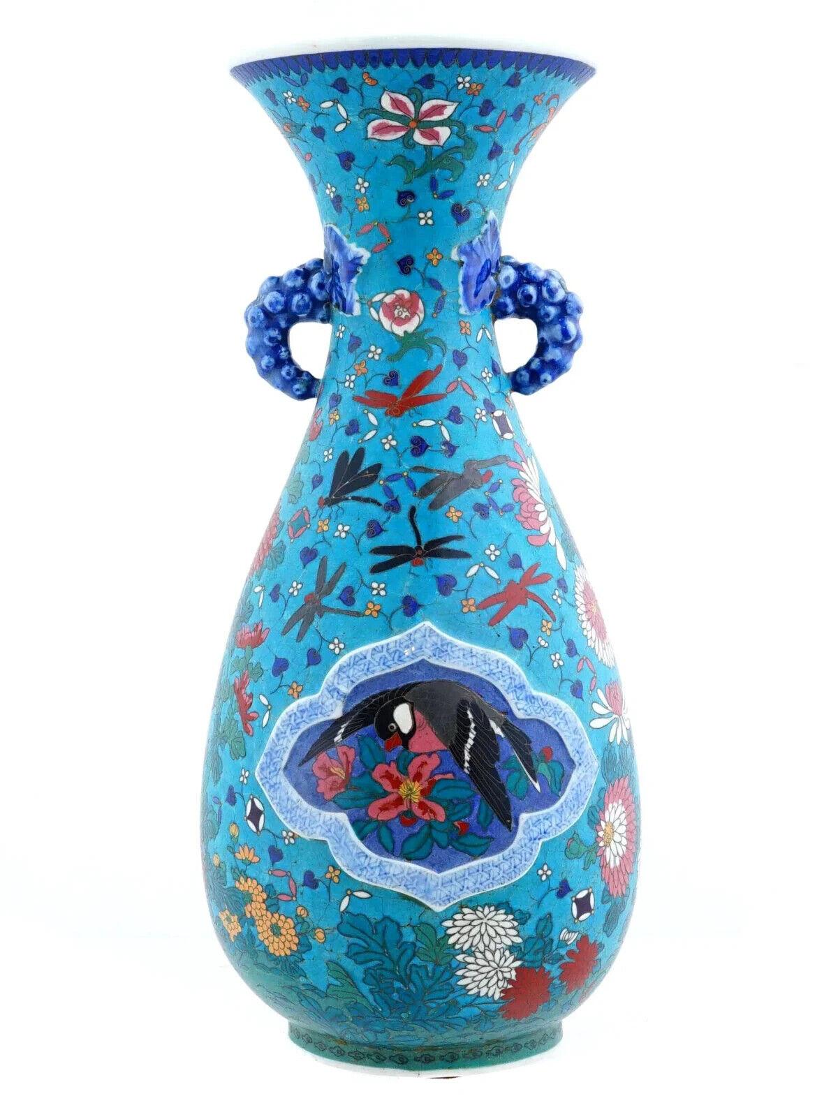 Un vaso giapponese in smalto su porcellana. Il vaso ha un corpo a forma di balaustro con bocca scanalata, ornato da un disegno policromo che rappresenta medaglioni con fiori in fiore e uccelli circondati da libellule, ornamenti floreali e fogliame
