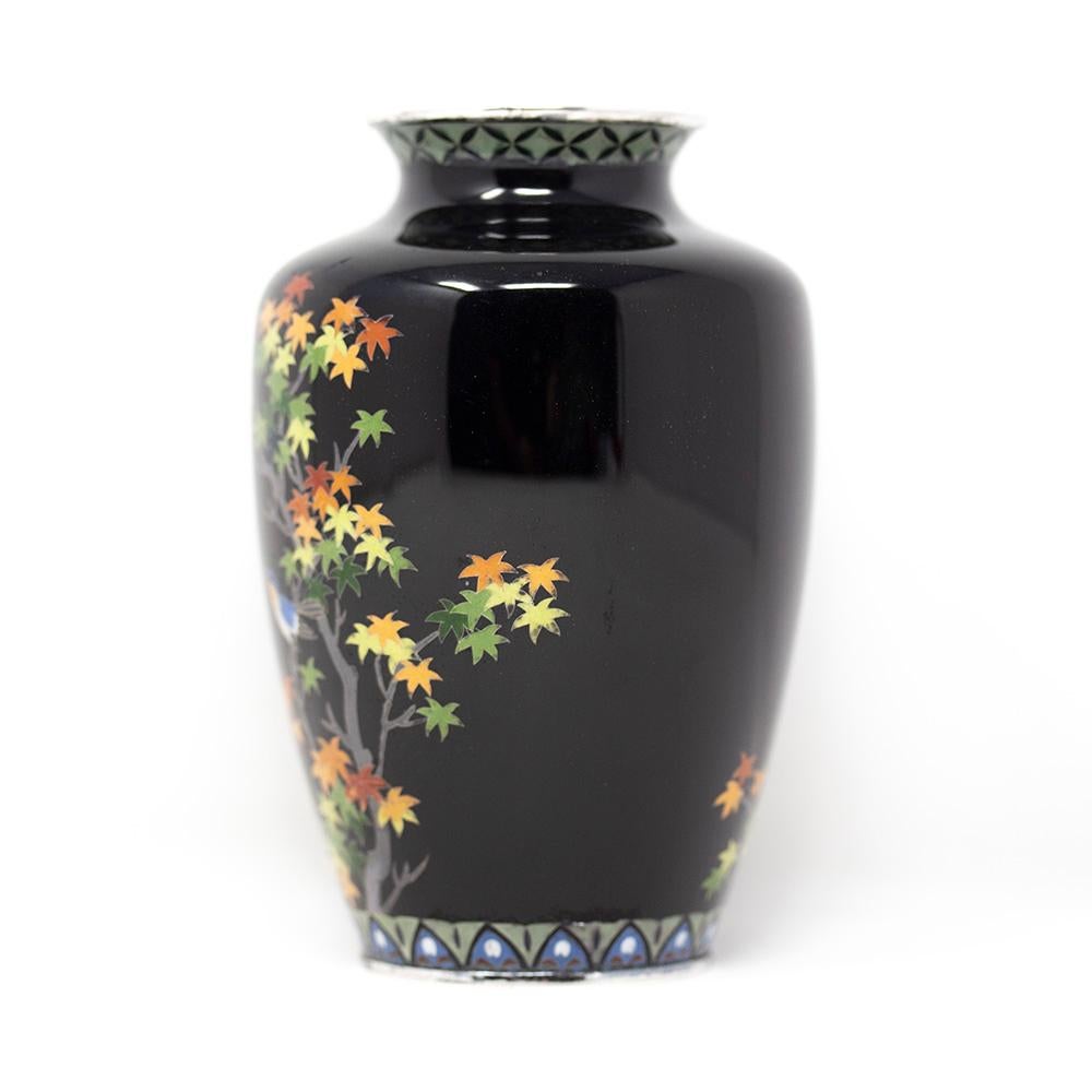Japanese cloisonne enamel vase. The vase of ovoid form with circular opening, black enamel glaze and silver mounted rims. Boldly decorated with autumnal flowers and birds. To the top and bottom geometric patterns finish the vase.

Notes Ando