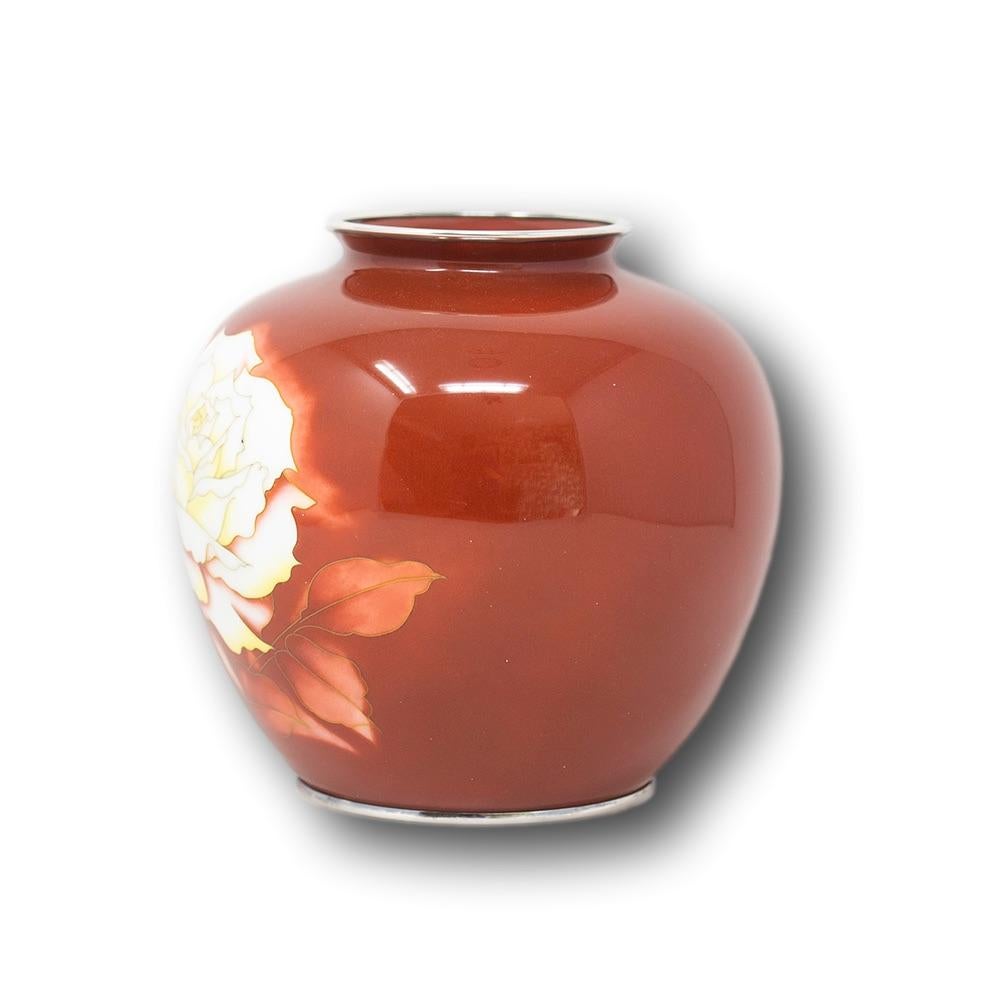 Japanese cloisonne enamel vase. The vase of globular form with tightly pinched neck and splayed opening decorated with a fine red ground enamel worked with wire and musen-shippo (wireless technique) with a central white rose with yellow tips