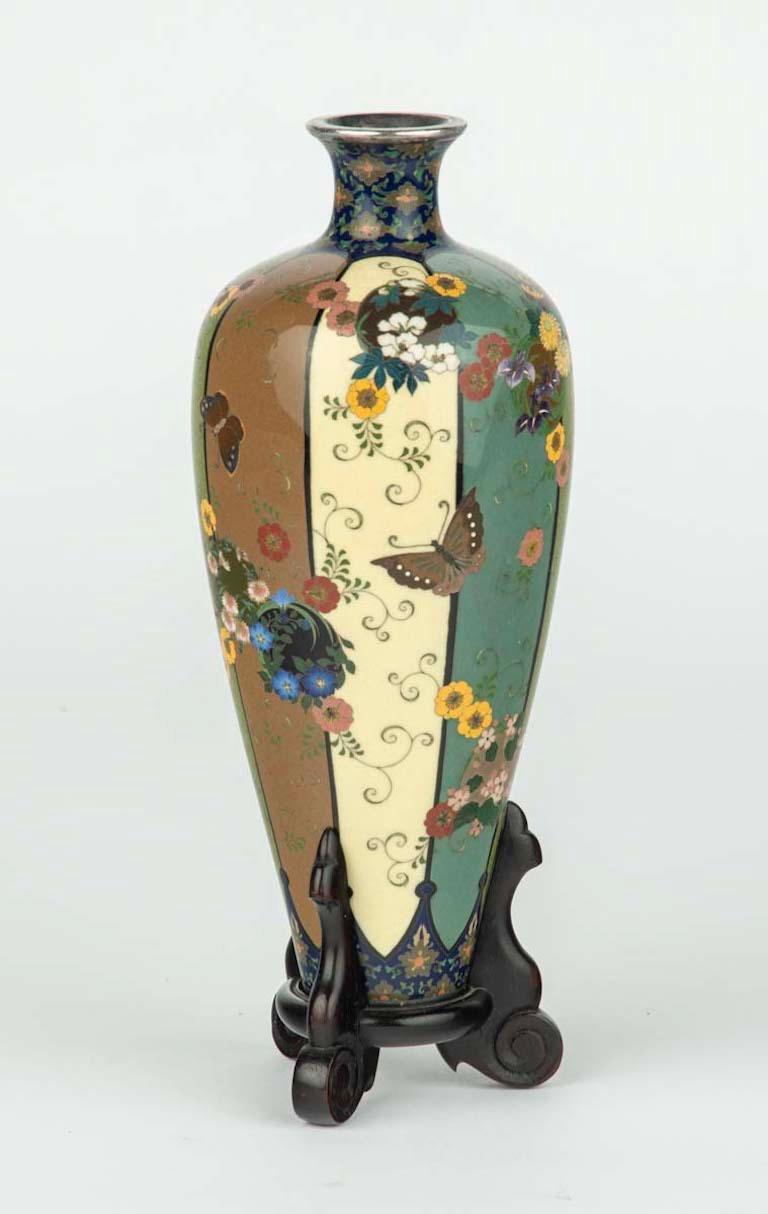 Dans le cadre de notre collection d'œuvres d'art japonaises, nous sommes ravis de proposer ce superbe vase en émail cloisonné de la période Meiji (1868-1912), réalisé par l'artiste impérial Namikawa Yasuyuki. Ce grand vase effilé est finement