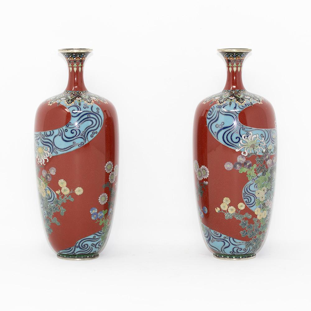 Fine opposing pair of Japanese cloisonne enamel vases. The vases dated to the meiji period of elongated ovoid shape with a flared mouth, tapered neck and flat foot. Decorated with an abstract flowing blue ribbon through the centre of the vase with