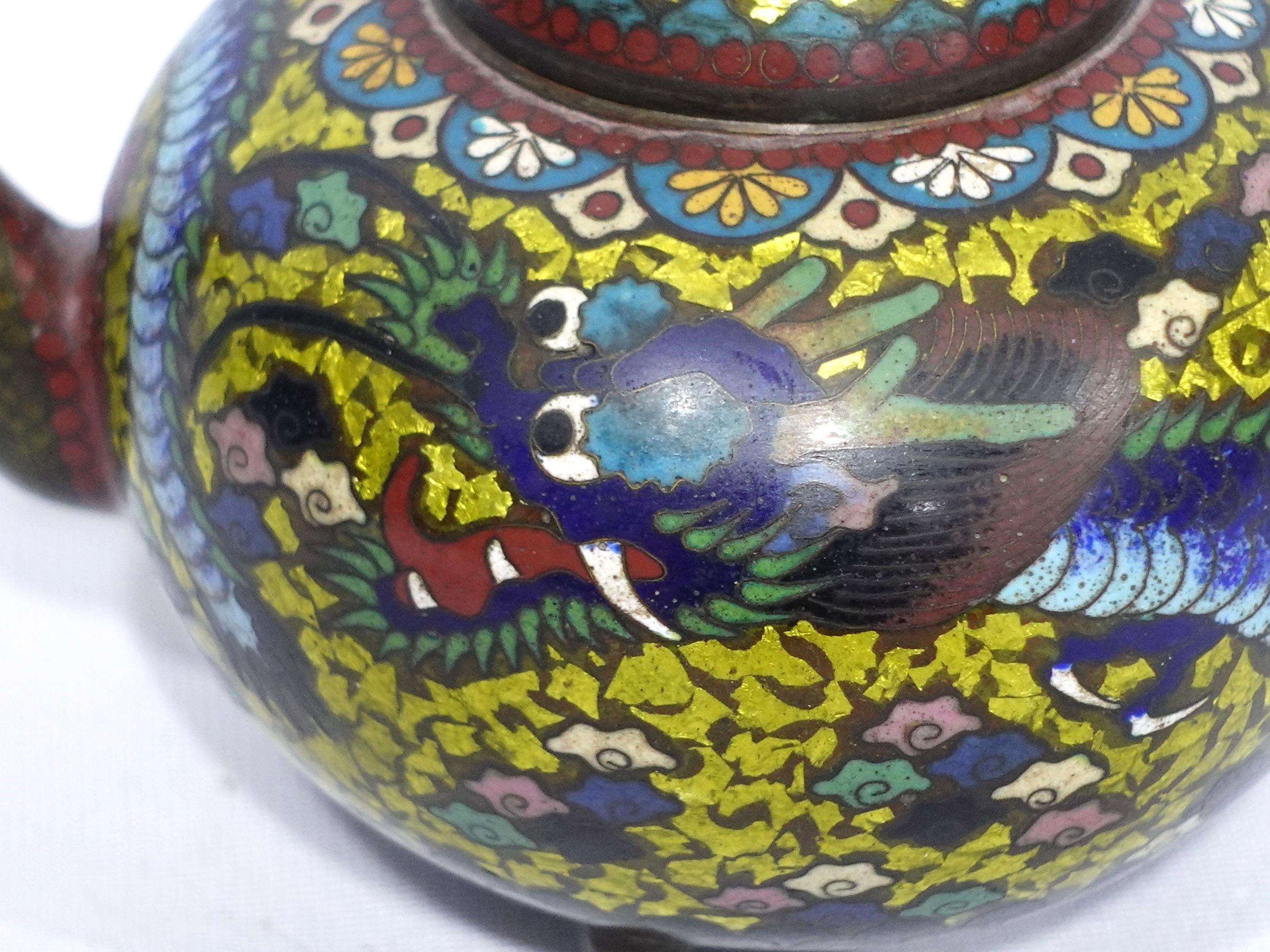 Quality work, amazing workmanship with absolutely fine details bronze cloisonné enameled teapot depicting the scene of a flying dragon with vivid colors of yellow, light golden green, red, blue, and brown, and 3 feet applied underneath.
