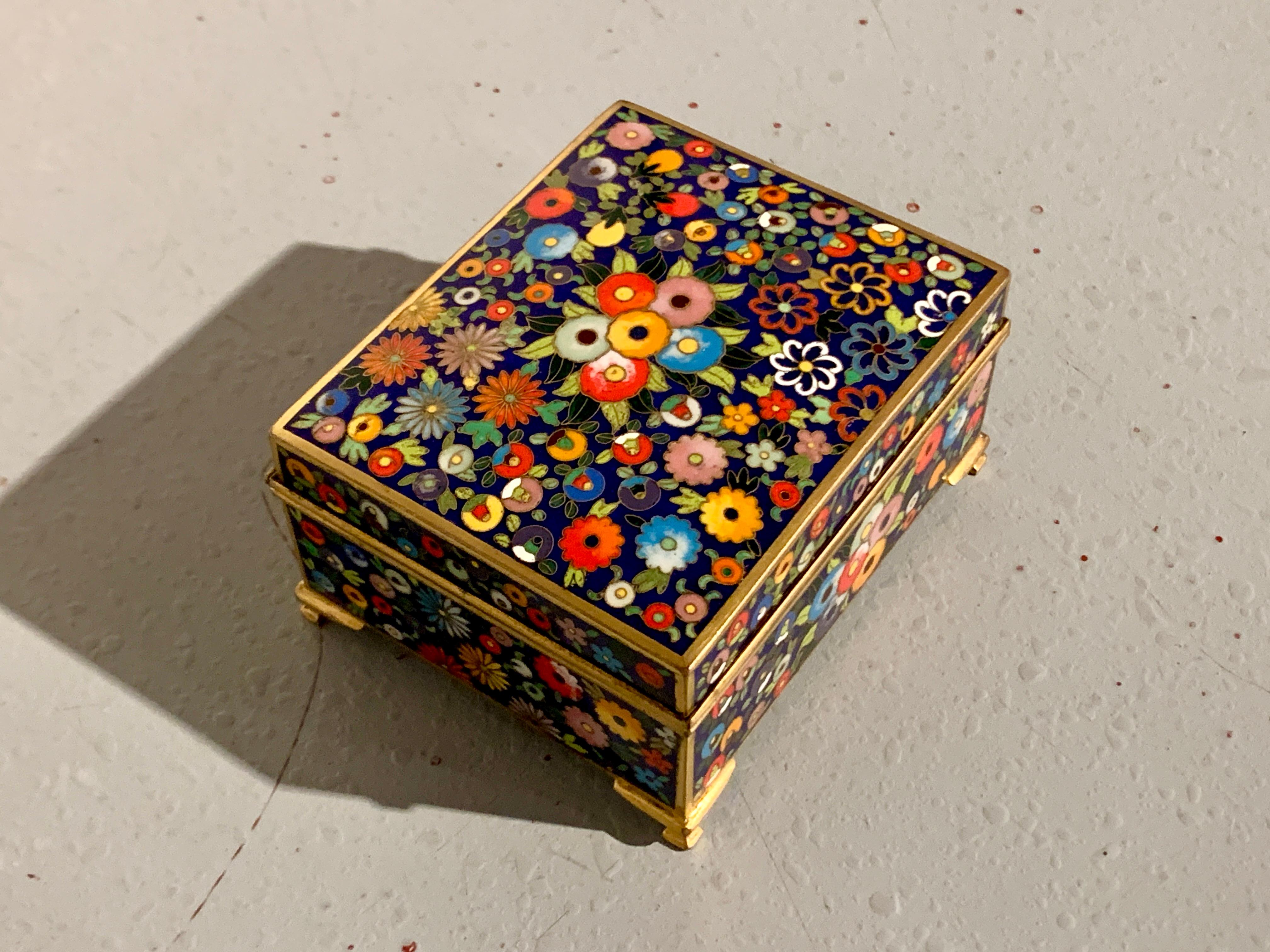 A fantastic small Japanese cloisonne trinket or jewelry box by Inaba, Taisho Period, circa 1920, Japan.

The cloisonne box with a slightly domed and hinged lid, set on raised feet. The box decorated all over in a dense millefleurs (thousand
