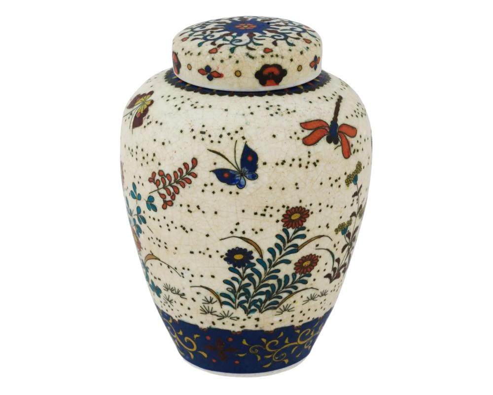 An antique Japanese late Meiji era covered Totai enamel on ceramic ginger jar. Circa: late 19th century

The ware is enameled with polychrome images of blossoming flowers, butterflies, and dragonflies made in the Cloisonne technique. The cover of