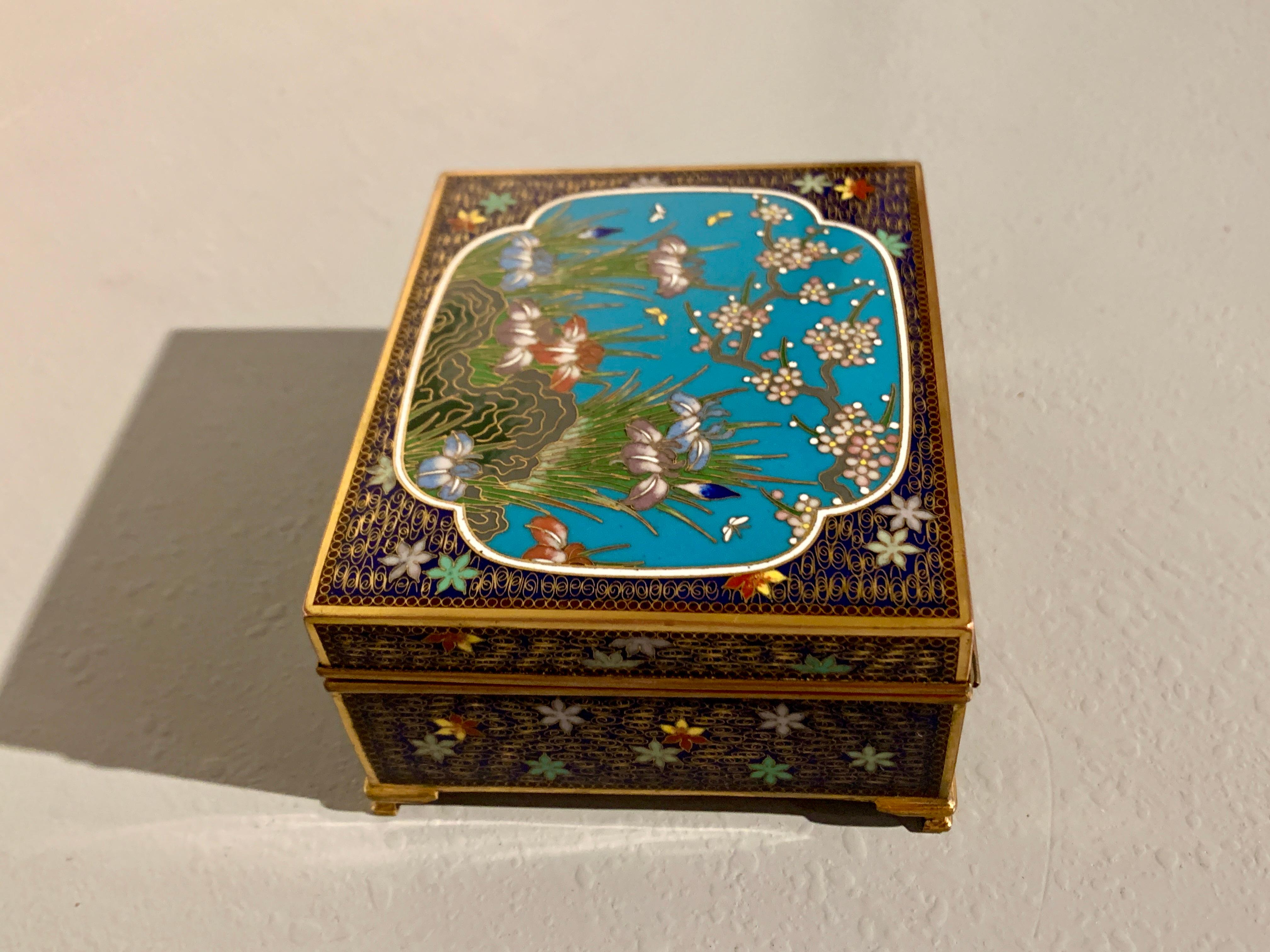 A delightful Japanese cloisonne trinket box with iris and cherry blossom design, Meiji Period, circa 1900, Japan.

The lovely box decorated in the cloisonne enamel technique. The hinged top features a large central quatrefoil reserve with irises,