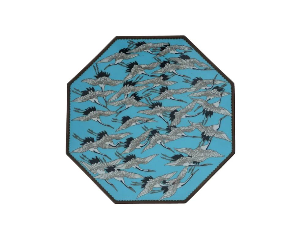 An antique Japanese, Meiji era, enamel over copper plate or charger attributed to Hayashi Kodenji, Japanese, 1831 to 1915. Circa 1890.

The plate has an octagonal form.

The interior of the plate is enameled with a polychrome image of cranes on the