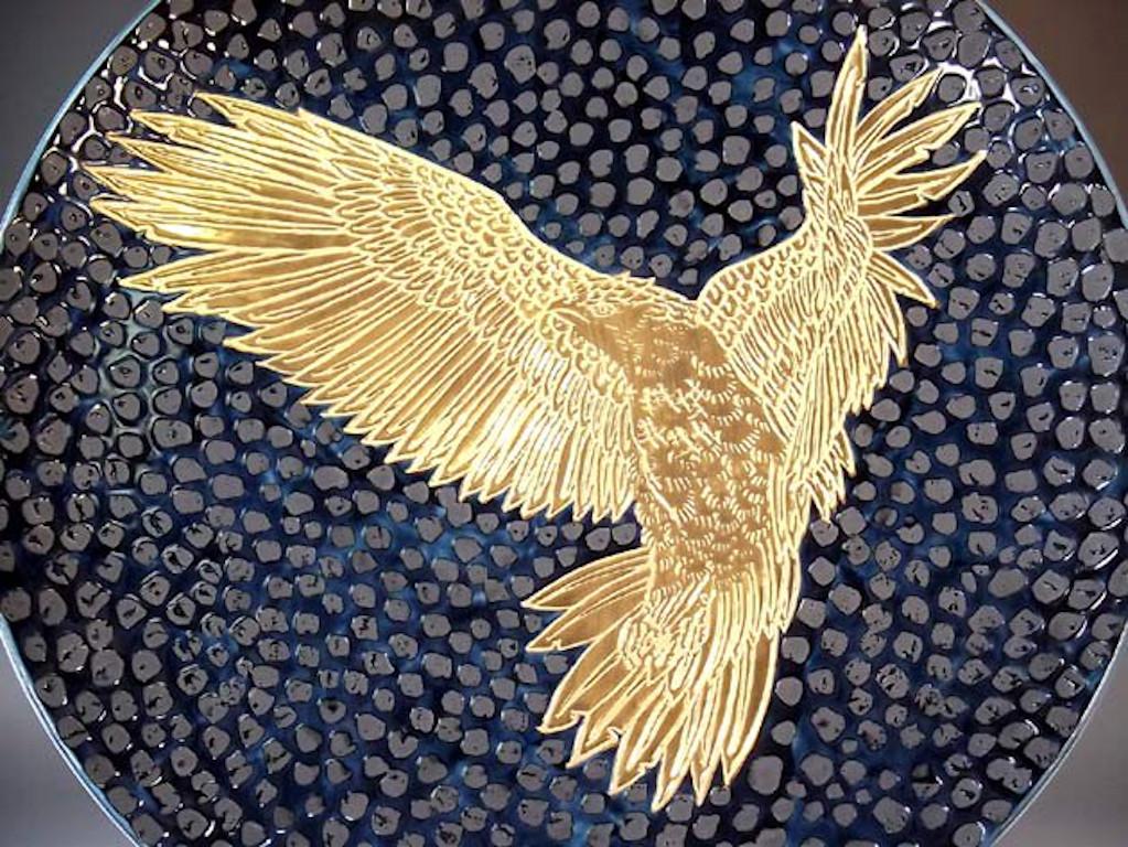 Exquisite Japanese contemporary large gilded, intricately hand painted and dimpled porcelain charger by acclaimed master porcelain artist, dramatically showcasing an eagle in flight, with intricate gold details, set against a dimpled black