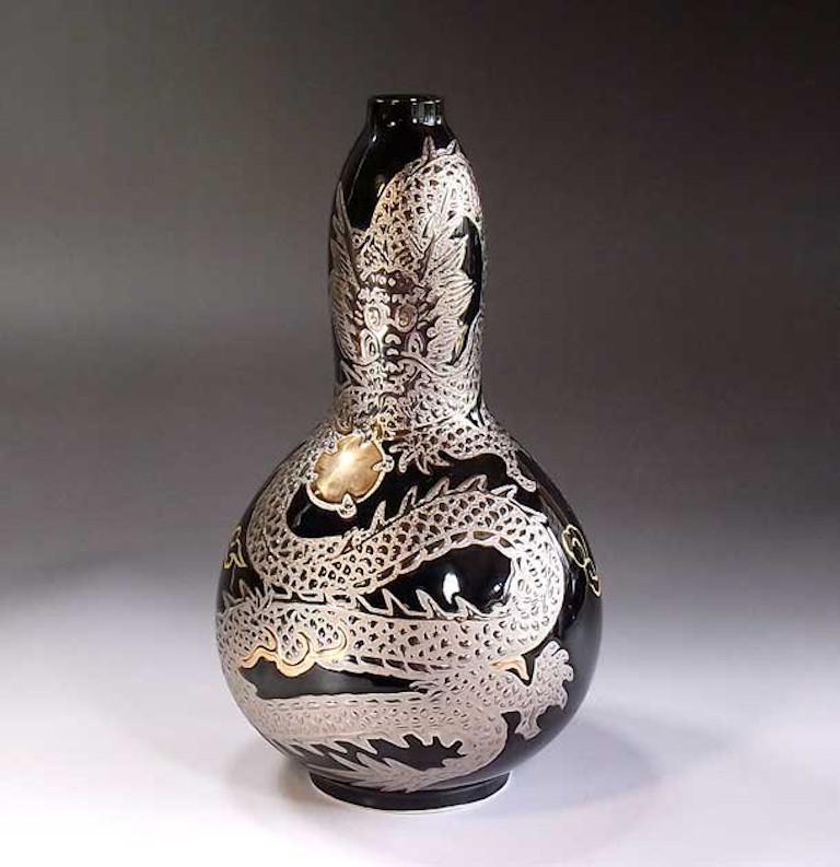 Unique contemporary Japanese porcelain vase, hand painted showcasing a dramatic dragon set against a dimpled black background, a signed piece from the signature dragon collection by highly acclaimed master porcelain artist. In 2016, the British