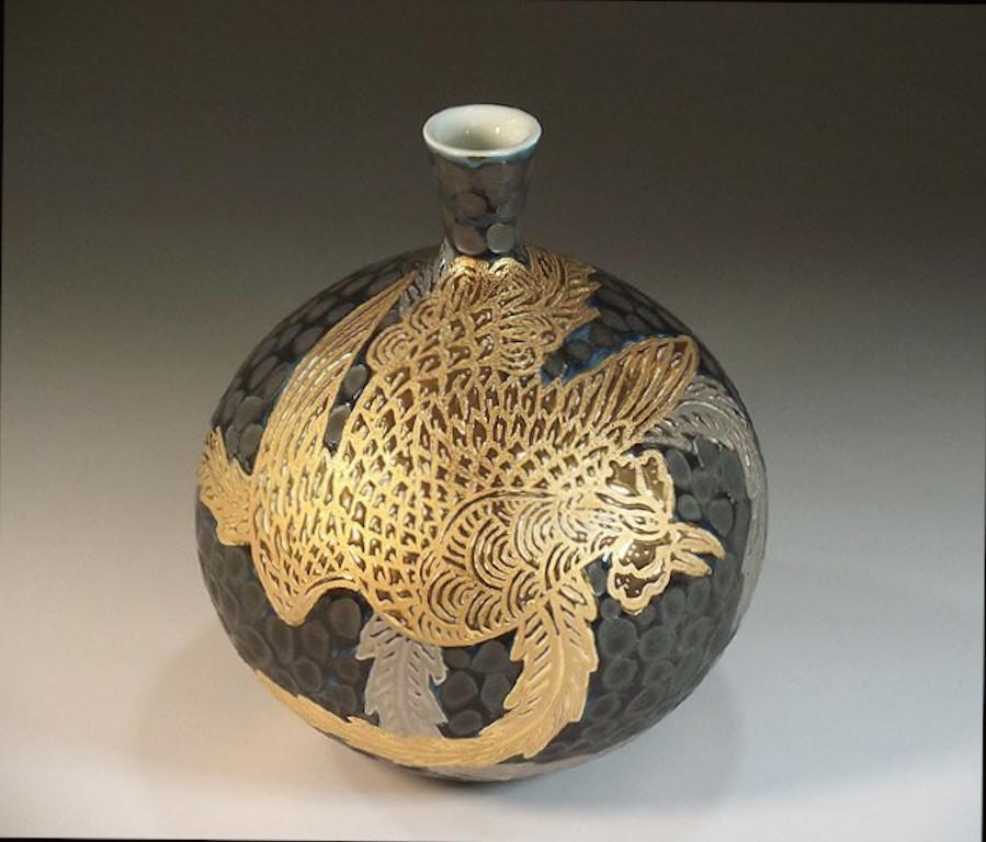 Exquisite Japanese dimpled decorative porcelain vase intricately hand painted in gold and platinum, showcasing a dramatic scene of a phoenix extending its beautiful long wings, set against a stunning black dimpled background. It is a signed