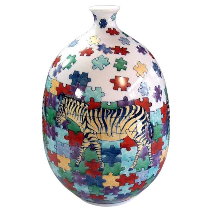 Unique Japanese contemporary decorative porcelain vase, hand painted in green, yellow, blue, red and black over a stunning bottle shaped body, a beautiful piece from a signature collection with zebra and puzzle pattern by highly acclaimed Japanese