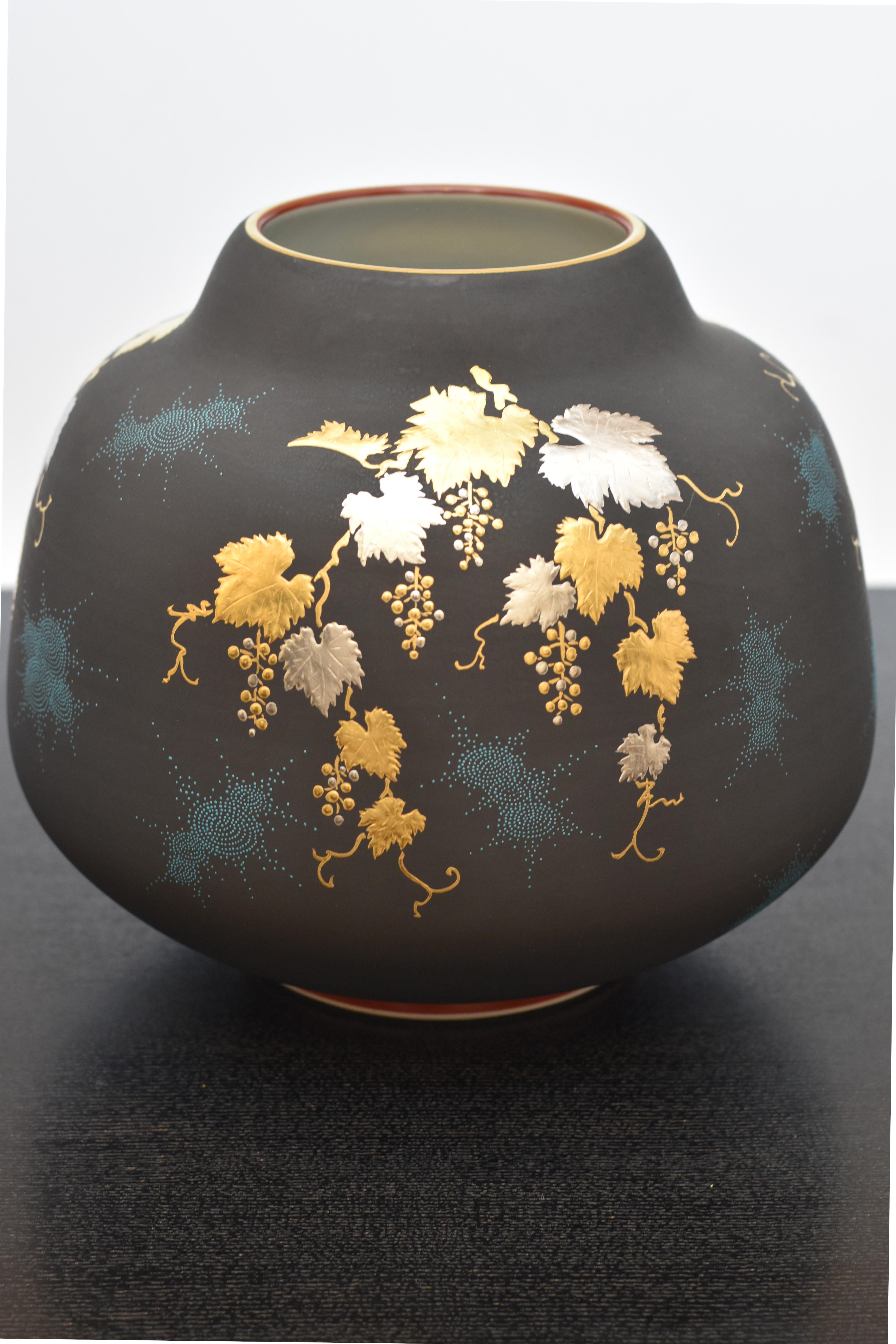Exquisite museum quality signed Japanese contemporary porcelain vase, a masterpiece by a highly celebrated award-winning third-generation porcelain artist of the Kutani region of Japan featuring a cascade of grape vines rendered in pure gold and