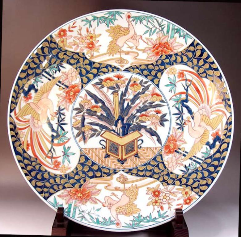 Chrysanthemum, peony, bamboo, plum, phoenix, crane, arabesque pattern

Extraordinary contemporary Japanese Ko-Imari style large decorative porcelain charger, hand painted in gold, blue, pink and red, a signed masterpiece by widely acclaimed