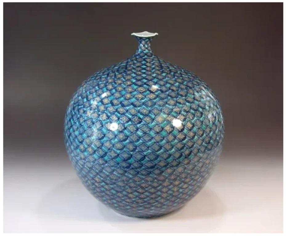 Exquisite contemporary Japanese decorative porcelain vase, intricately hand painted in dark blue and turquoise blue and intricate gold details, on a stunningly shaped porcelain body, by widely acclaimed master porcelain artist in traditional