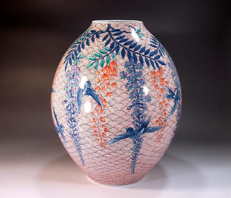 Japanese contemporary decorative porcelain vase, hand painted in blue, green and orange on a beautifully shaped porcelain body, a signed piece by highly acclaimed porcelain artist of Japan’s Imari-Arita region. The artist is the recipient of