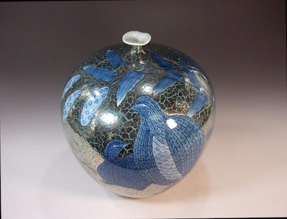 Contemporary Japanese porcelain decorative vase, stunningly hand painted in underglaze cobalt blue, set against a unique crackled background in platinum, an elegantly shaped globular porcelain body. It is a signed piece by highly respected