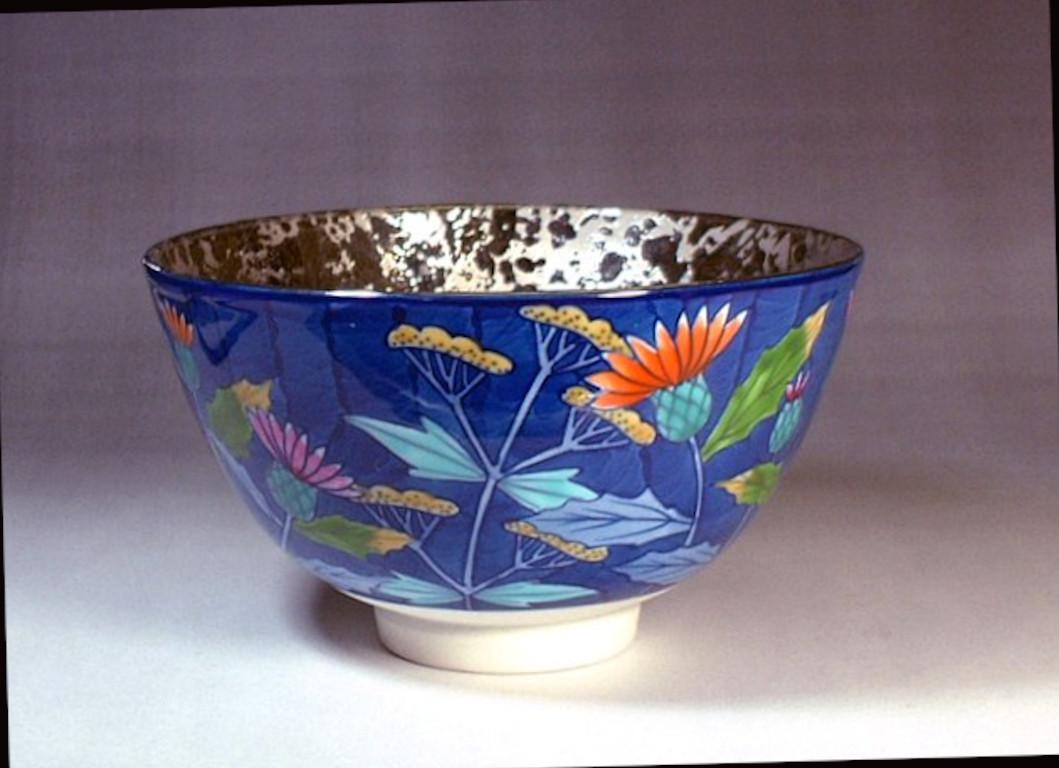 Exquisite contemporary Japanese porcelain matcha tea bowl, a unique piece platinum-gilded on the inside and hand painted in vivid pink and green on the outside set against a textured deep blue background. It is a work by highly acclaimed porcelain