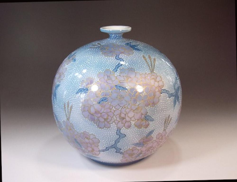 Contemporary Japanese decorative porcelain vase, extremely intricately hand painted in various shades of blue and pink set against a beautifully shaped ovoid porcelain body in a beautiful textured blue background, to create a mesmerizing surface. It