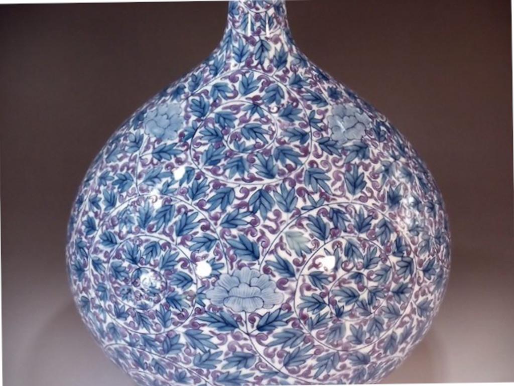 Squisito vaso decorativo giapponese contemporaneo in porcellana, intricatamente dipinto a mano in blu e viola su un elegante corpo a forma di bottiglia, un pezzo firmato da un acclamato maestro di porcellana della regione di Imari Porcelain in
