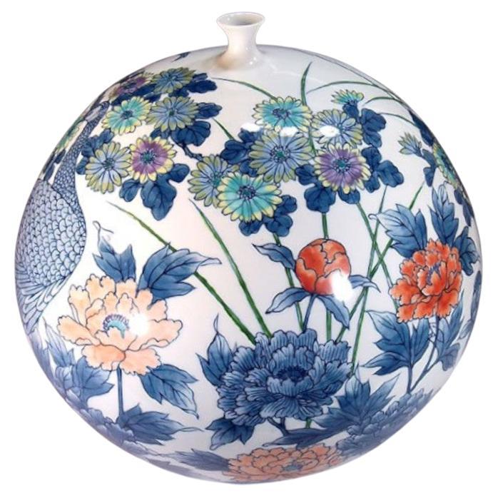 Exquis vase contemporain japonais en porcelaine décorative, peint à la main en vert, rouge et bleu vifs, une œuvre signée par un maître artiste en porcelaine très acclamé de la région d'Imari-Arita au Japon. Il a reçu de nombreux prix pour son