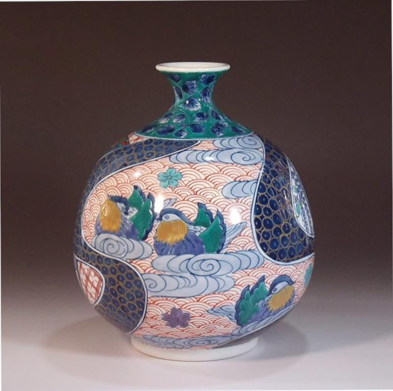 Japanese contemporary porcelain decorative porcelain vase, hand painted in red and blue on a beautifully shaped ovoid porcelain body, a signed piece by widely acclaimed Japanese master porcelain artist in the Imari-Arita tradition. In 2016, the