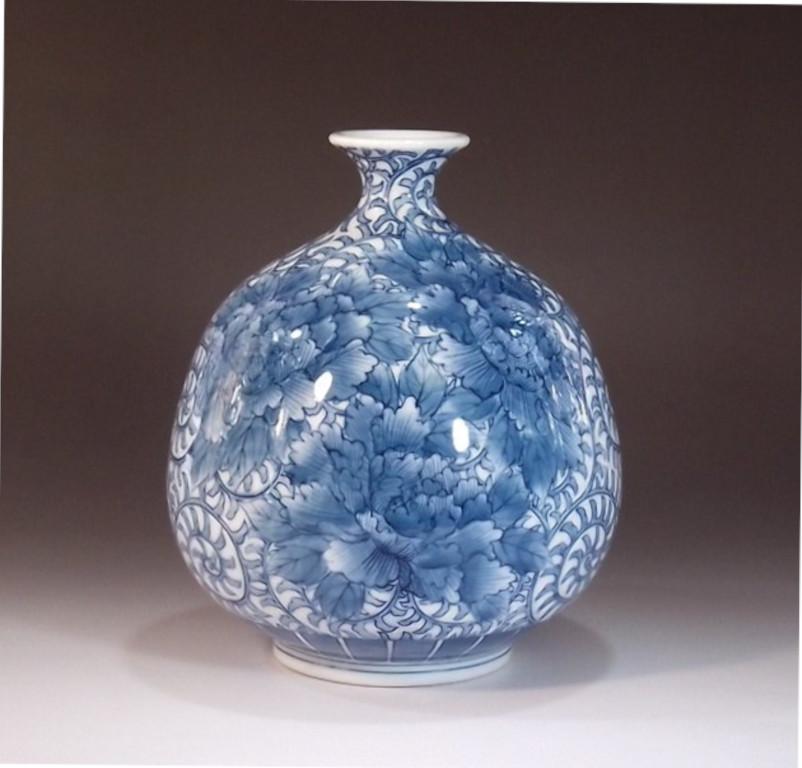 Exquisite contemporary Japanese decorative porcelain vase, intricately hand painted in blue underglaze and red on a stunningly shaped porcelain body, the work of widely acclaimed master porcelain artist in traditional patterns of the Imari-Arita
