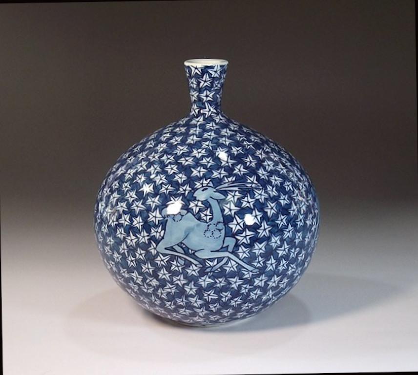 Exquisite contemporary Japanese decorative porcelain vase, intricately hand painted in various shades of blue on a stunning auspicious bottle shape body, a signed work by master porcelain artist from the Arita-Imari region in Japan . In 2016, the