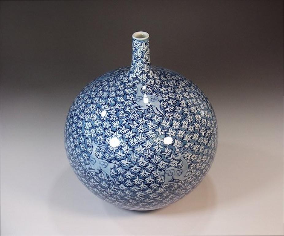 Exquisite contemporary Japanese decorative porcelain vase, intricately hand painted in various shades of blue on a stunning bottle shape body, a signed work by highly acclaimed award-winning Japanese master porcelain artist . In 2016, the British
