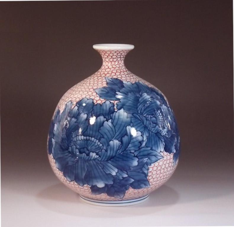 Vase contemporain en porcelaine décorative japonaise présentant deux panneaux de pivoines en pleine floraison sur fond d'un délicat motif d'arabesque auspicieuse japonaise en bleu sous glaçure. Ce vase aux belles dimensions est la création d'un