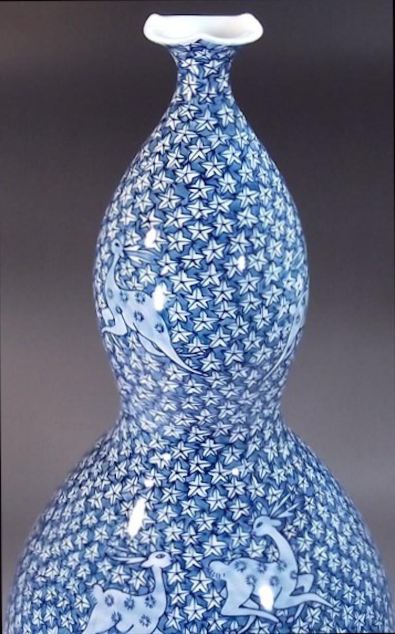 Exquis vase en porcelaine décoratif japonais contemporain de grande taille, peint à la main de manière complexe dans différentes nuances de bleu sur un corps en forme de double gourde de bon augure, une œuvre signée par un maître porcelainier de la