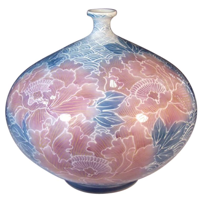 Exquisite Japanese contemporary porcelain vase, hand painted in blue and pink, the signed work by master artist of the Imari- Arita region of Japan dramatically featuring giant soft salmon pink peonies set against a white background adorned with a