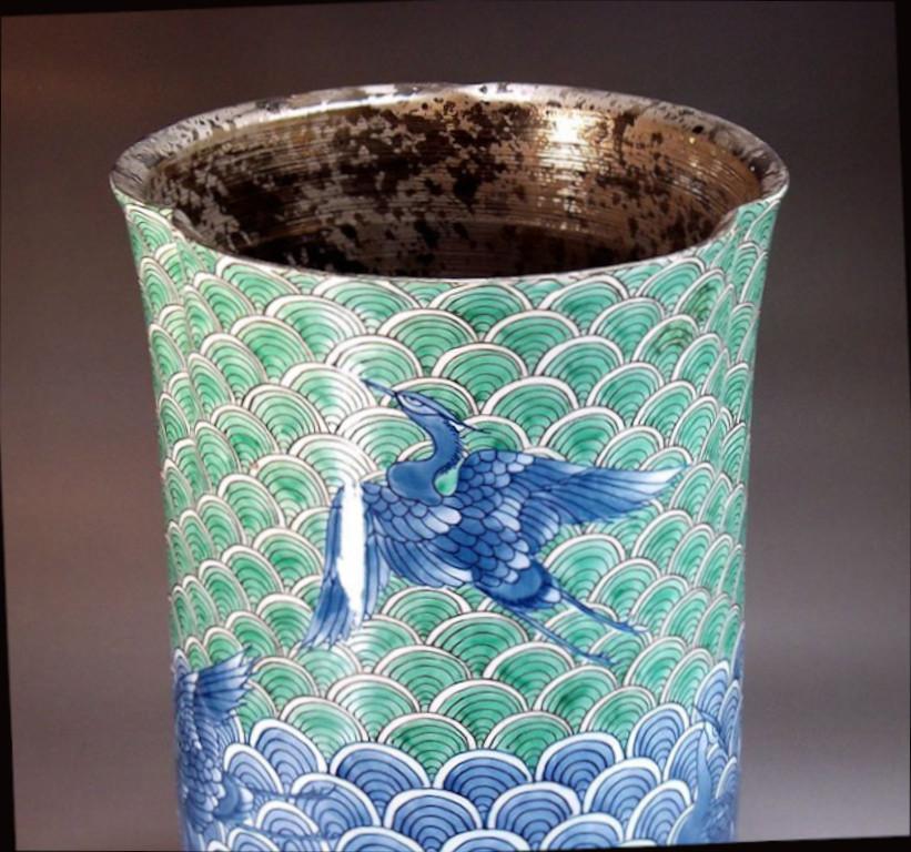 Exquis vase contemporain japonais en porcelaine décorative, peint à la main de façon complexe en platine, vert et bleu vifs, sur un corps de forme cylindrique élégante avec un bord festonné sophistiqué. Il s'agit d'une œuvre signée d'un maître