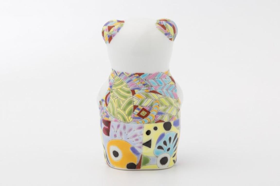 Exquisite Japanese contemporary porcelain bear sculpture, intricately hand-painted in blue, yellow and green in an auspicious traditional Japanese aya pattern consisting of diagonal geometric designs by Japanese artist from the historic Imari-Arita