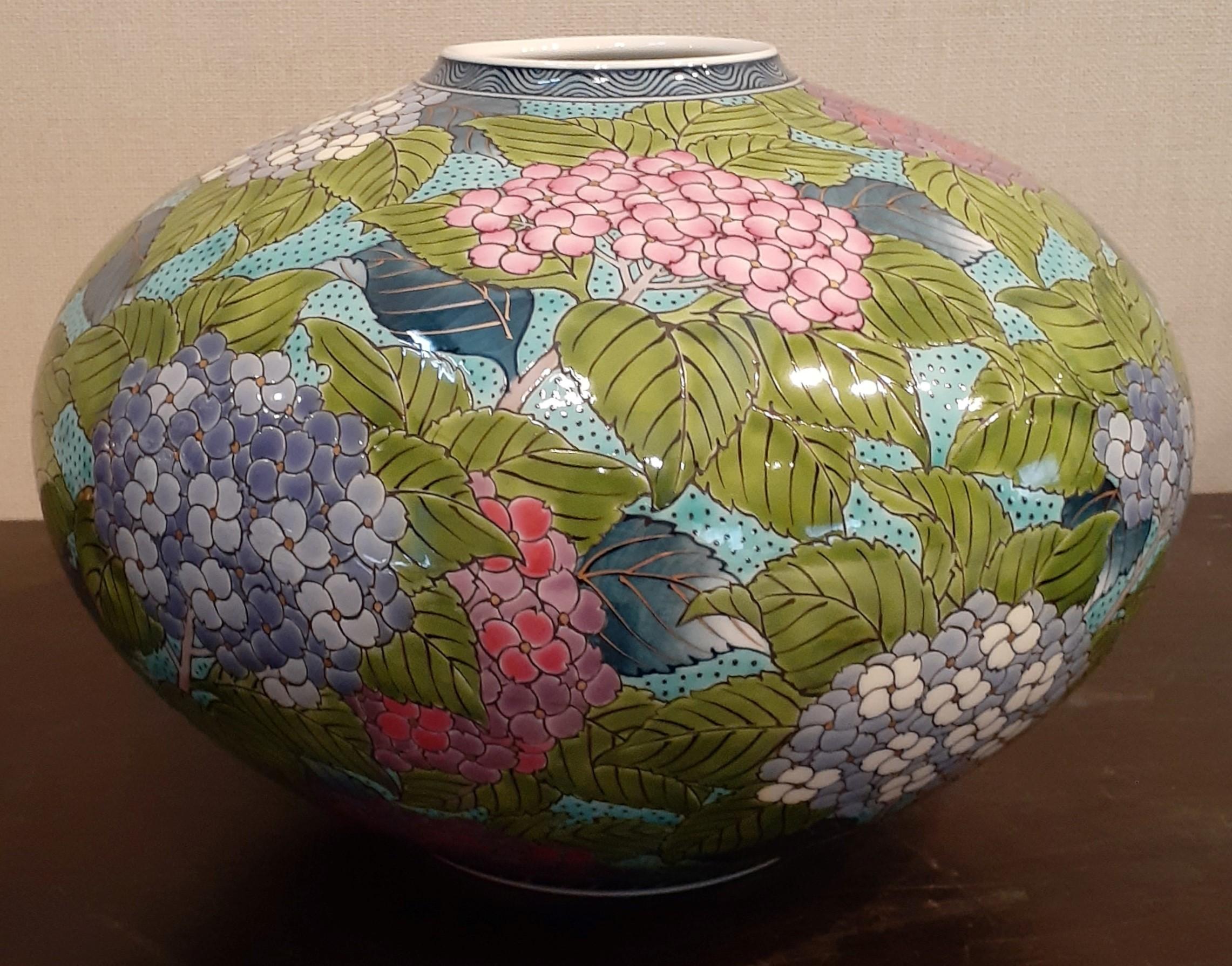 Mesmerizing contemporary Japanese porcelain vase, intricately hand painted showcasing hydrangeas in vibrant red, pink, blue on a beautifully shaped porcelain body in a stunning turquoise blue. It is a signed masterpiece by highly acclaimed