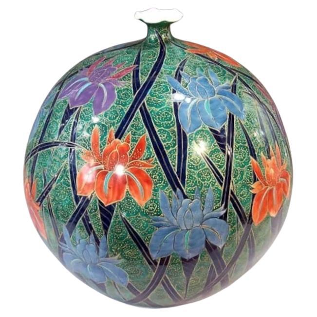 Squisito vaso decorativo giapponese contemporaneo in porcellana, dipinto a mano in verde, blu, rosso e viola su un corpo dalla forma sorprendente e firmato da un maestro di porcellana ampiamente acclamato della regione giapponese di Imari-Arita. Nel