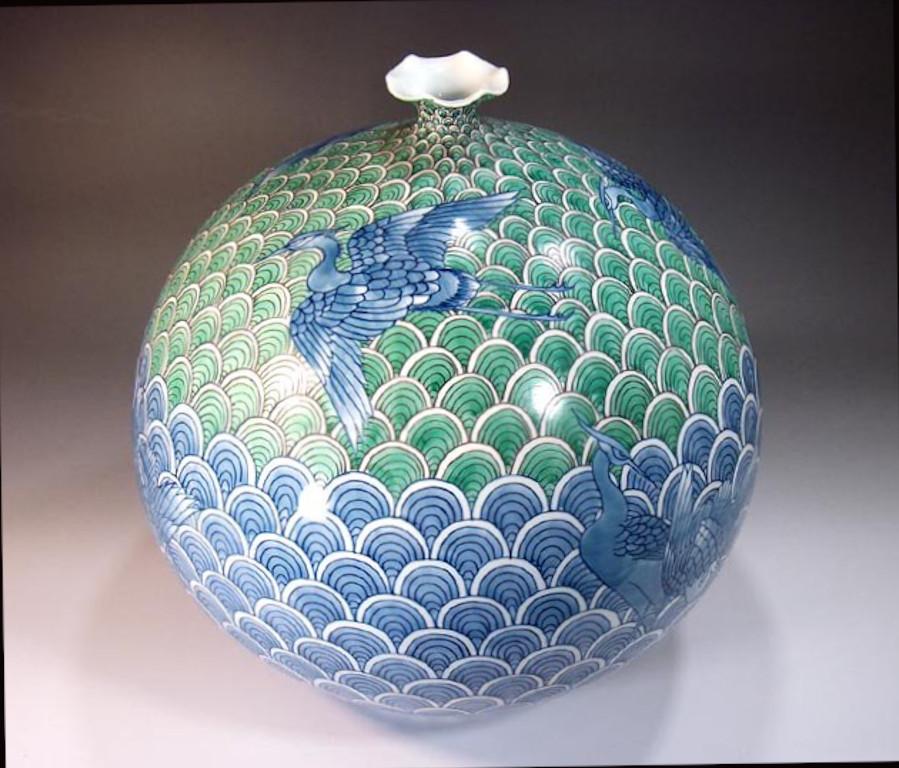 Exquisite Japanese contemporary decorative porcelain vase, intricately hand-painted in vivid green and blue on an elegant globular shape, a signed work by highly acclaimed master porcelain artist from the historic Imari-Arita region of Japan and