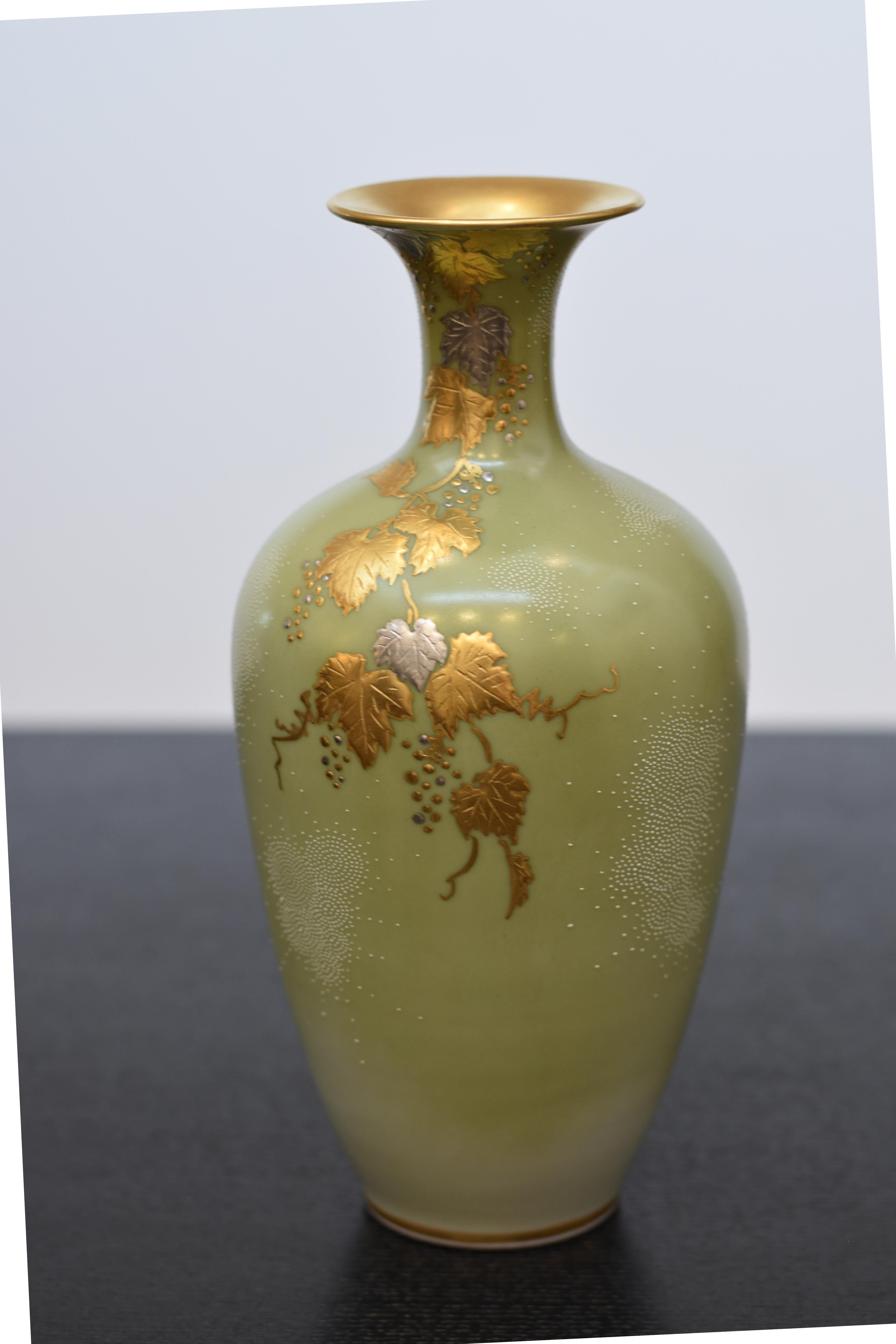 Exceptional museum quality signed Japanese contemporary porcelain vase, a masterpiece by a celebrated award-winning third-generation porcelain artist of the Kutani region of Japan featuring a cascade of grape vines rendered in pure gold and platinum