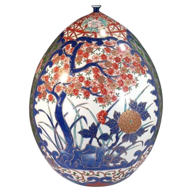 Exceptional Japanese contemporary decorative porcelain vase, intricately hand-painted on a stunning egg-shape porcelain body in blue, red and green with extensive gold details, a signed masterpiece by highly acclaimed master porcelain artist, and