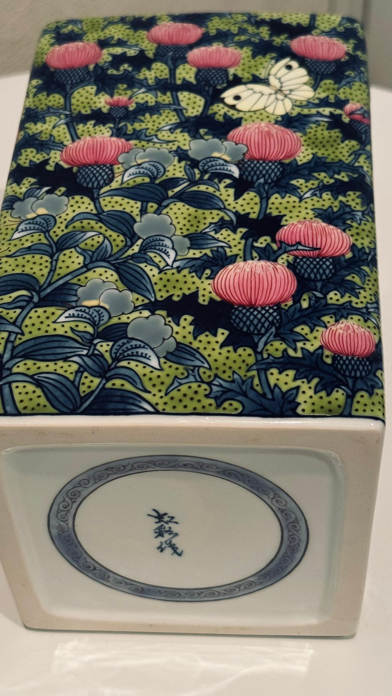 This extraordinary Japanese contemporary museum-quality decorative porcelain vase features a patch of thistle plants and flowers -- a traditional motif in Imari-Arita porcelain art. The occasional butterfly attracted to the early summer bloom adds a