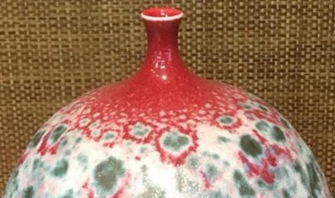 Exquisite Japanese contemporary hand-glazed decorative porcelain vase in a stunning graceful form in the artist's signature red and green, creating a mesmerizing pattern named 