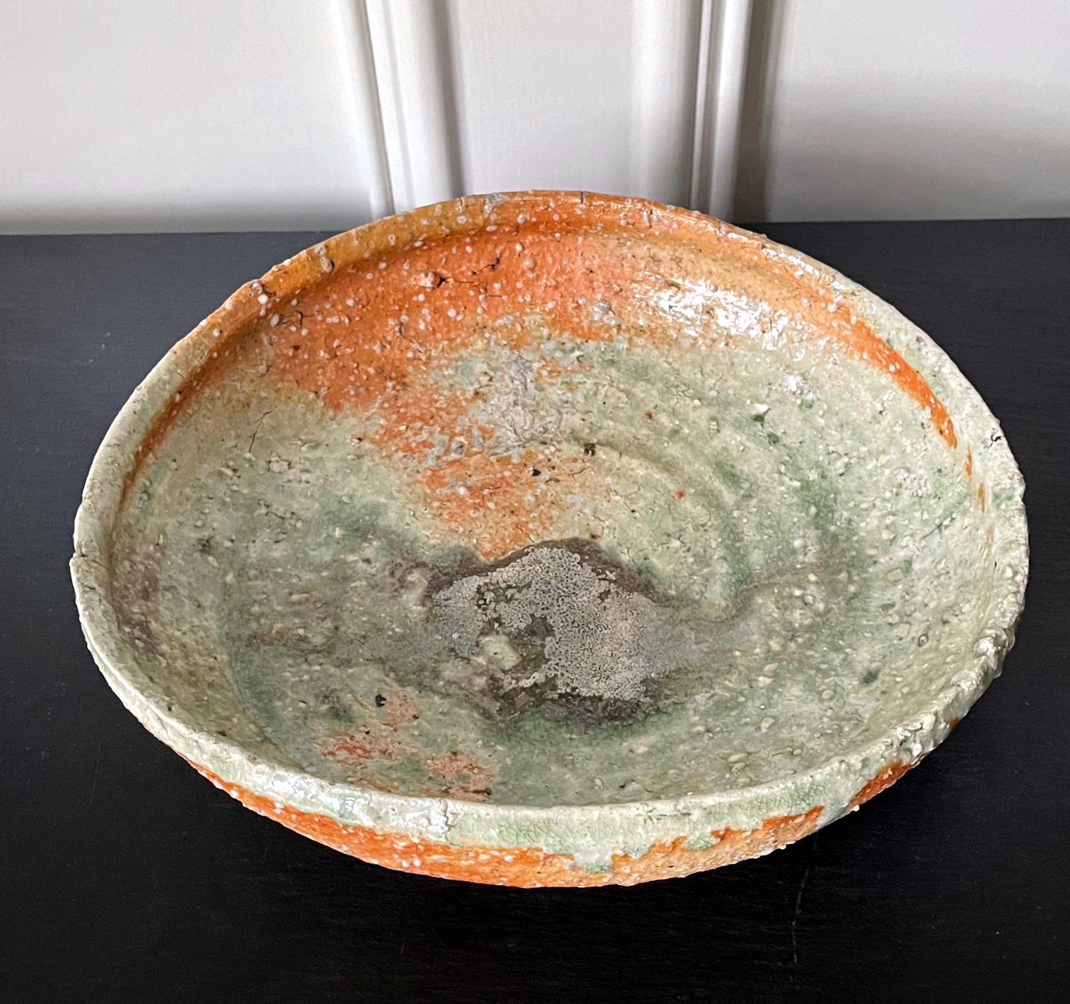 A contemporary Stoneware Bowl made in the tradition of Iga ware by Japanese ceramic artist Shiro Tsujimura (1947-). In a slightly irregular round form, the deep bowl is called Hachi in Japanese. They are reminiscent of the alms bowl monks hold for
