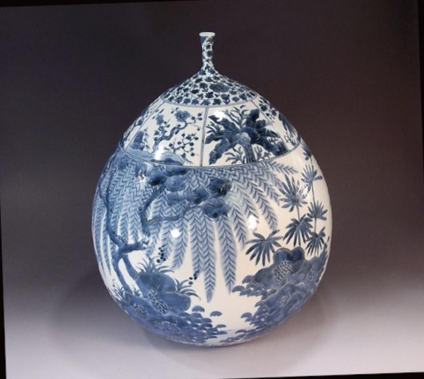 Exquis vase contemporain japonais en porcelaine décorative, peint à la main en bleu sous glaçure sur un corps magnifiquement façonné en blanc pur, une pièce signée par un maître artiste en porcelaine largement acclamé de la région d'Imari-Arita au