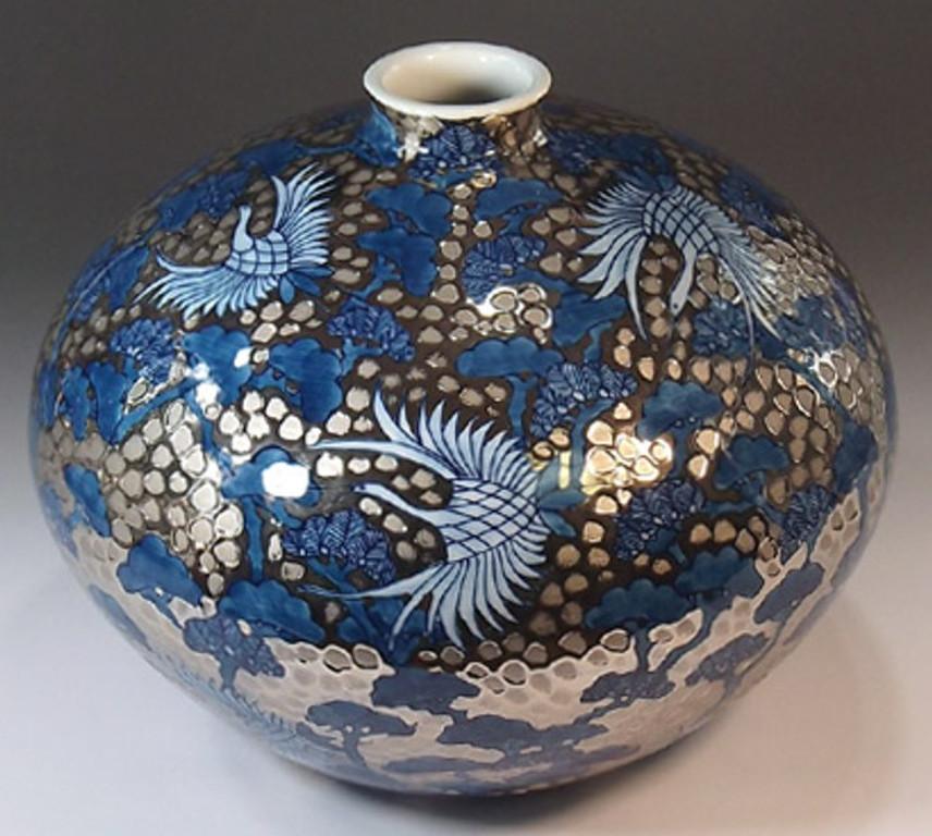 Exquisite Japanese contemporary platinum-gilded and dimpled porcelain vase decorated with a striking pine and phoenix motif in beautiful shades of blue underglaze, by widely respected master porcelain artist in the Imari-Arita style and the