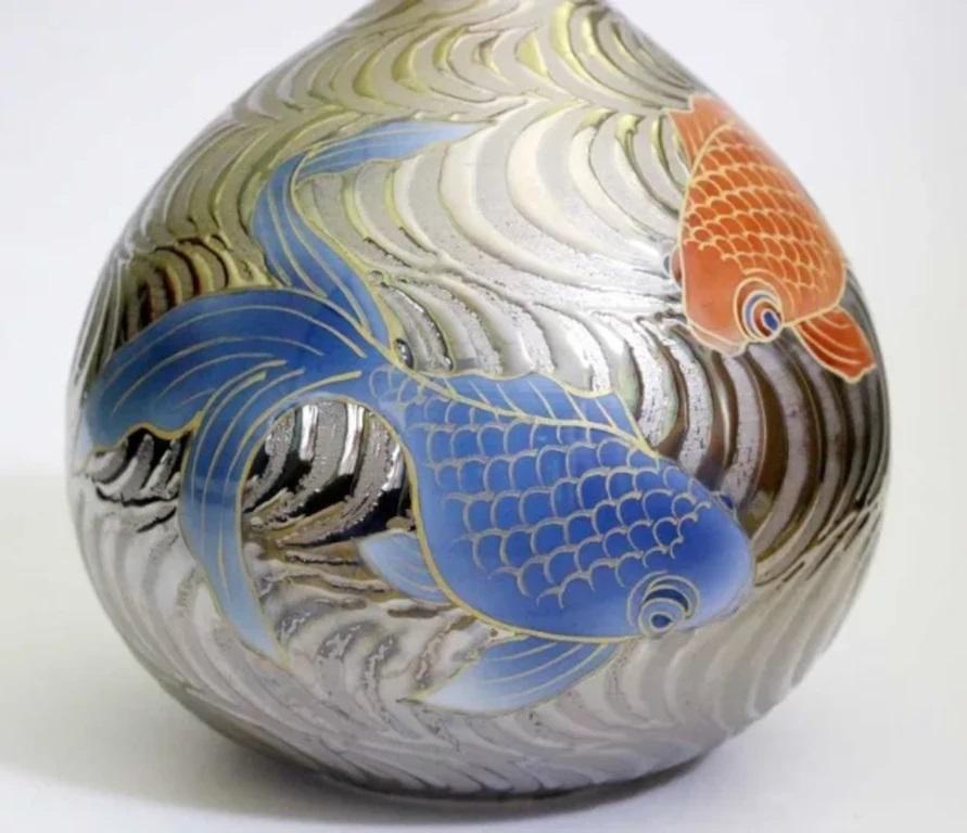 Squisito vaso decorativo giapponese contemporaneo in porcellana, dipinto a mano in rosso ferro e blu, su un suggestivo sfondo a onde in platino, combinato con un generoso uso di contorni in oro. Si tratta di un capolavoro firmato appartenente alla
