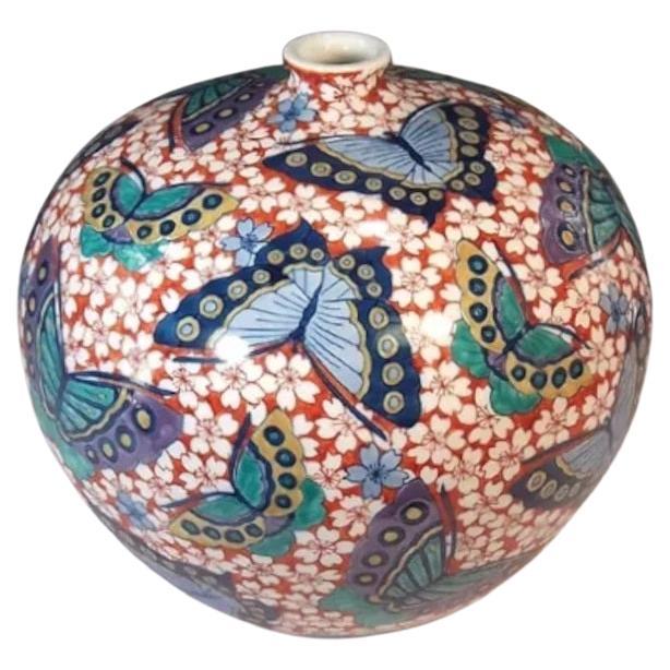 Contemporary Japanese porcelain decorative vase, intricately hand painted in vivid blue, red and green, a signed piece by a master porcelain artist in the Imari-Arita tradition. In 2016, the British Museum added a work by this artist to its