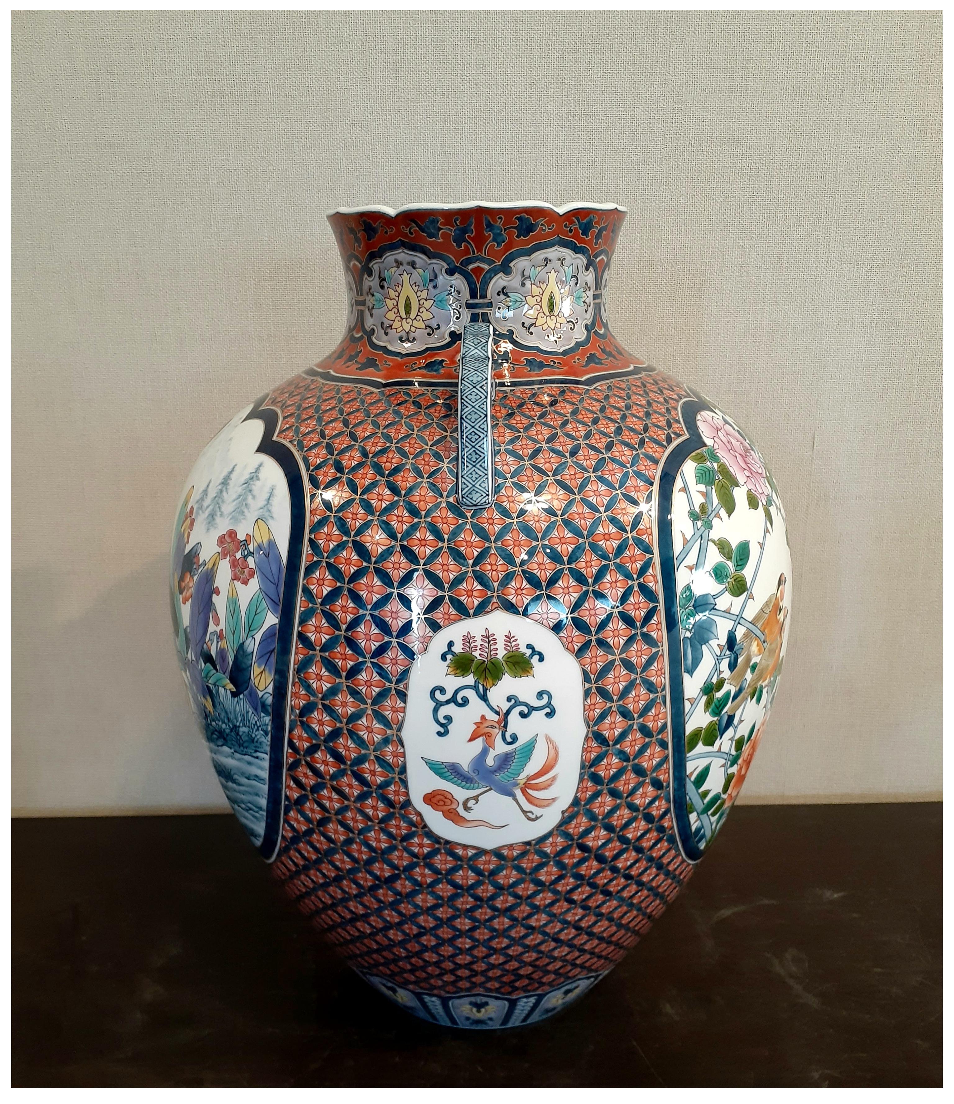Außergewöhnliche zeitgenössische japanische Vase aus vergoldetem, dekorativem Porzellan in Museumsqualität, aufwendig in Blau, Rot, Grün, Gelb und Orange gestaltet, auf einem atemberaubend geformten Korpus mit zwei anmutigen Henkeln. Ein prächtiges,
