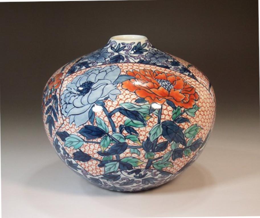 Exquisite contemporary Japanese decorative porcelain vase, intricately hand painted in red, blue and green on a stunningly shaped porcelain body, by widely acclaimed master porcelain artist in traditional patterns of the Imari-Arita region of Japan