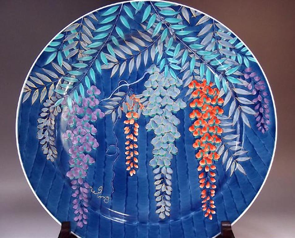 Japanese contemporary decorative porcelain charger, intricately hand painted in blue, purple and red, a signed piece by highly acclaimed master porcelain artist of Japan’s Imari-Arita region. The artist is the recipient of numerous awards for his