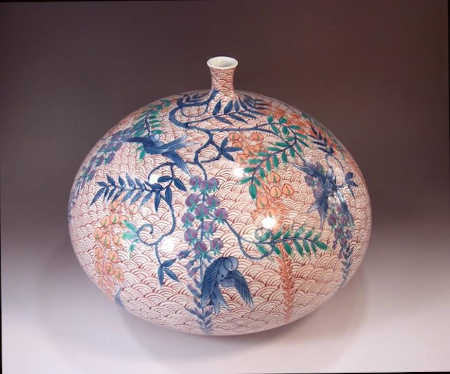 Exquisite Japanese contemporary decorative porcelain vase, intricately hand painted in blue, green, purple and red on a beautifully shaped ovoid porcelain body, a signed piece by highly acclaimed master porcelain artist of Japan’s Imari-Arita